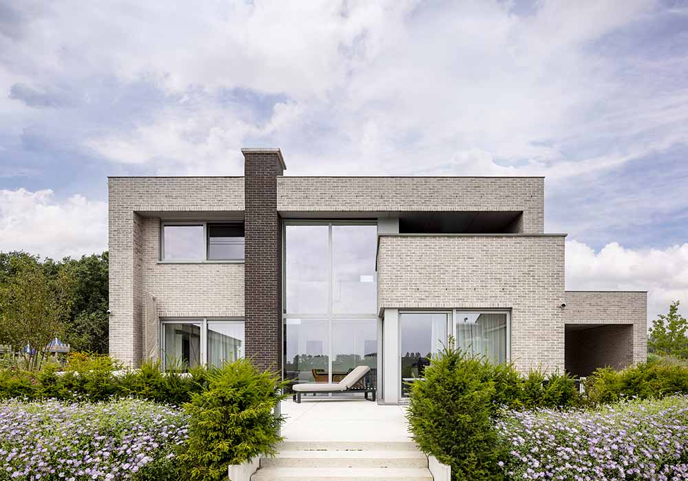 Moderne nieuwbouwvilla met strakke volumes en grote raampartijen, op maat gebouwd door Qubo.