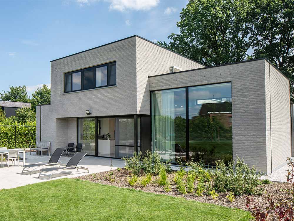 Moderne nieuwbouw met grote glaspartijen die maximaal daglicht binnenbrengen.