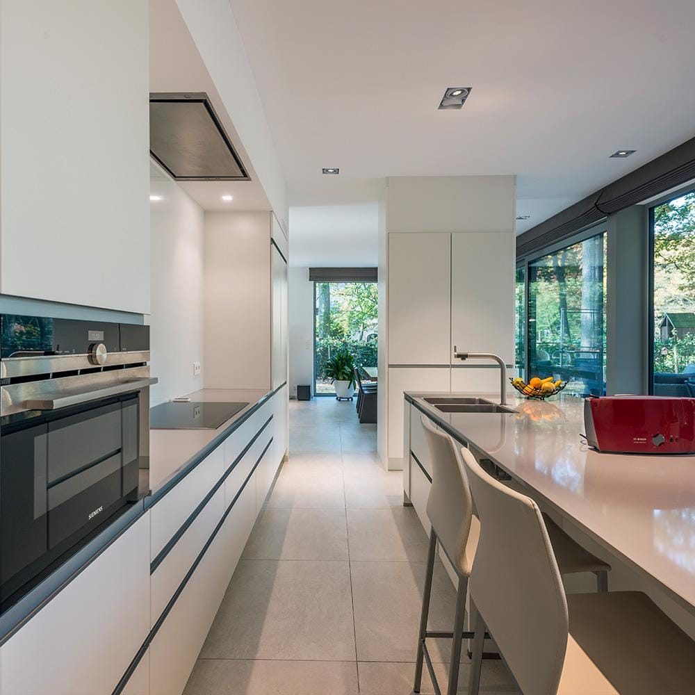 Moderne villa met grootformaat vloertegels in betonlook in de leefruimte.